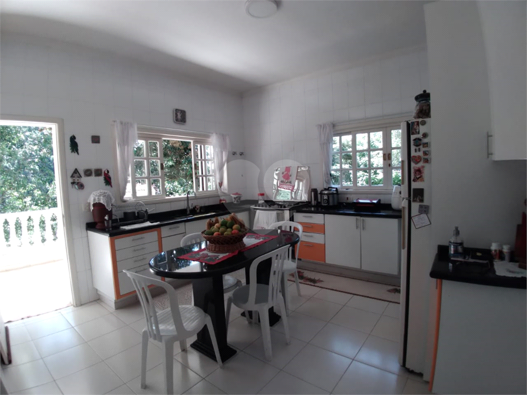 Casa com 3 pavimentos, com varanda, 5 suítes, localizada em Condomínio e com muita área verde.
