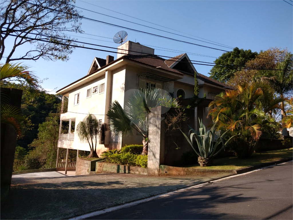 Casa com 3 pavimentos, com varanda, 5 suítes, localizada em Condomínio e com muita área verde.