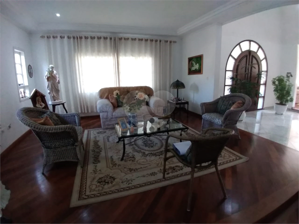 Casa com 3 pavimentos, com varanda, 5 suítes, localizada em Condomínio e com muita área verde.