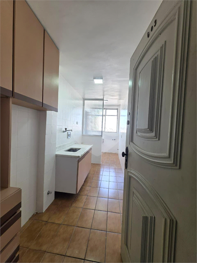 Cozinha ampla com armários e porta de entrada de serviço