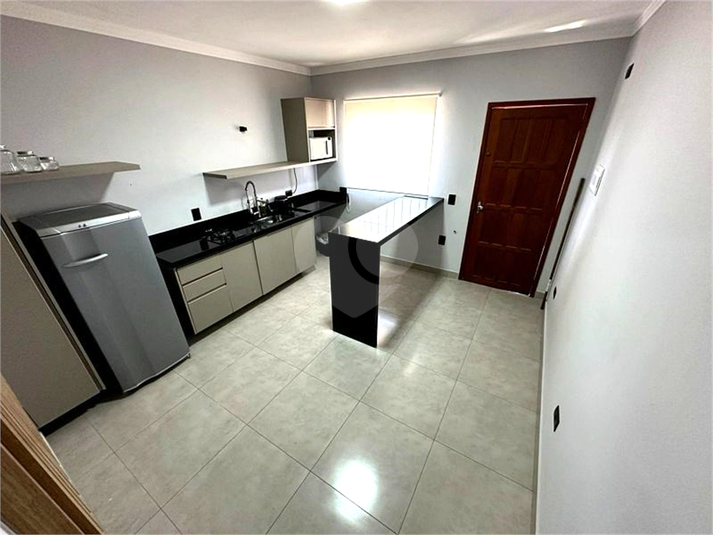 Cozinha americana moderna, com acabamento em mármore e porcelanato, equipada com fogão